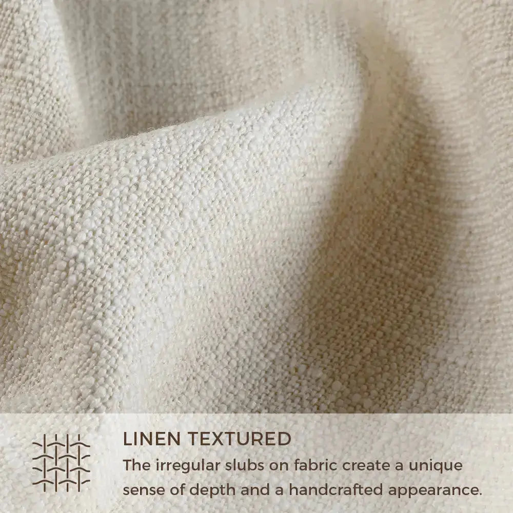 Natural undyed linen fabric close-up showing prominent irregular slubs creating a handcrafted textured appearance with visible depth