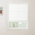 Photograph of an interior room showcasing a white window fitted with a translucent Roman blind partially open to a lush green outdoor view, with a framed Van Gogh landscape print on the adjacent light-colored wall