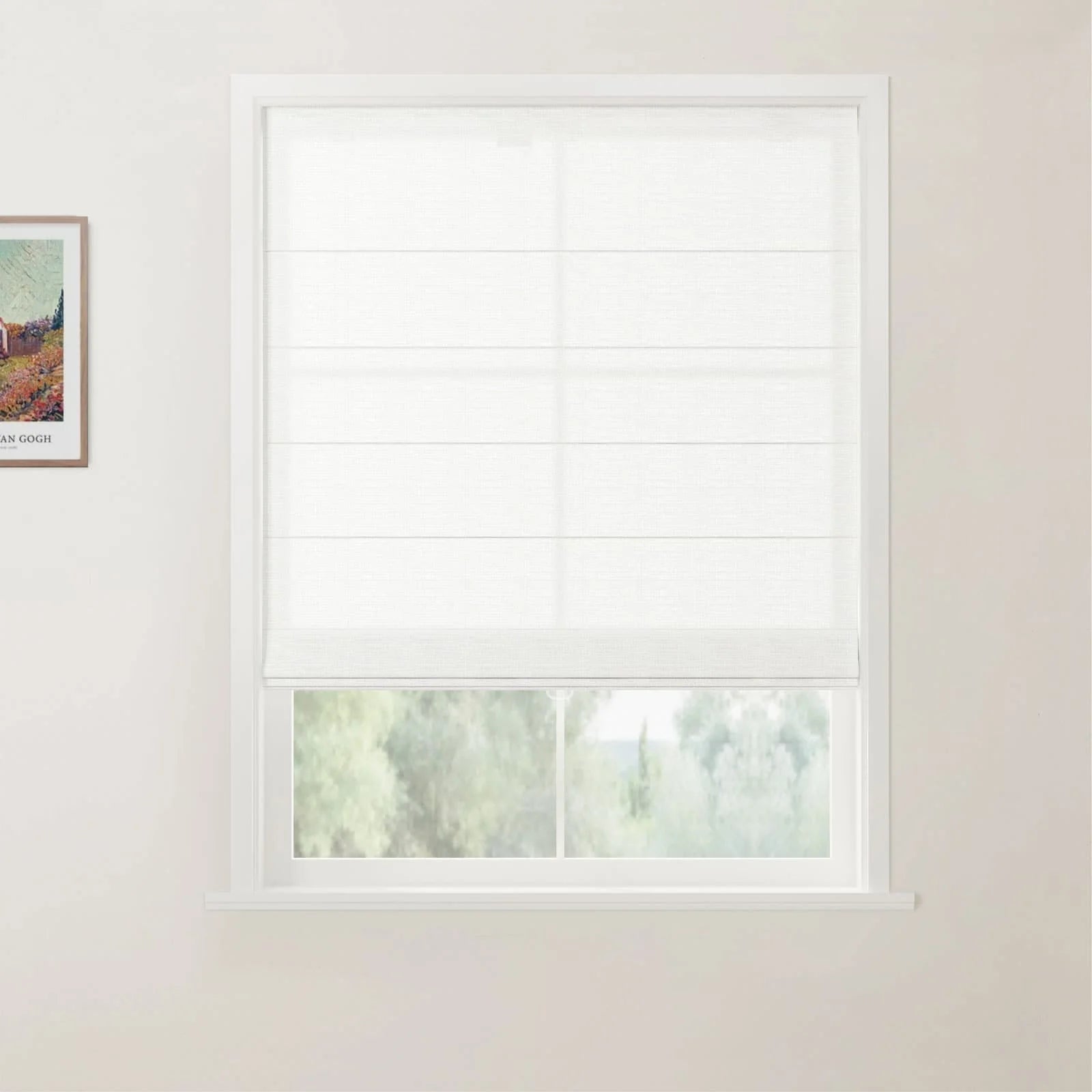 Photograph of an interior room showcasing a white window fitted with a translucent Roman blind partially open to a lush green outdoor view, with a framed Van Gogh landscape print on the adjacent light-colored wall