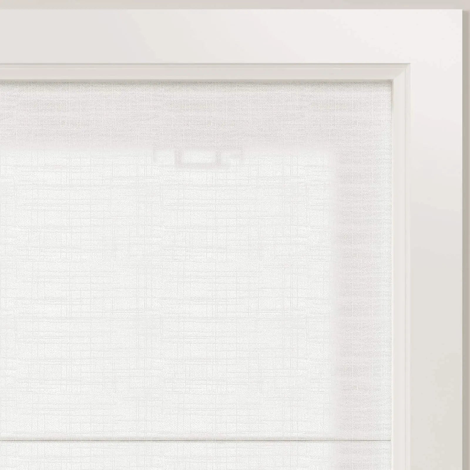 Photograph of a white textured window blind inside a clean white frame showing subtle light filtering