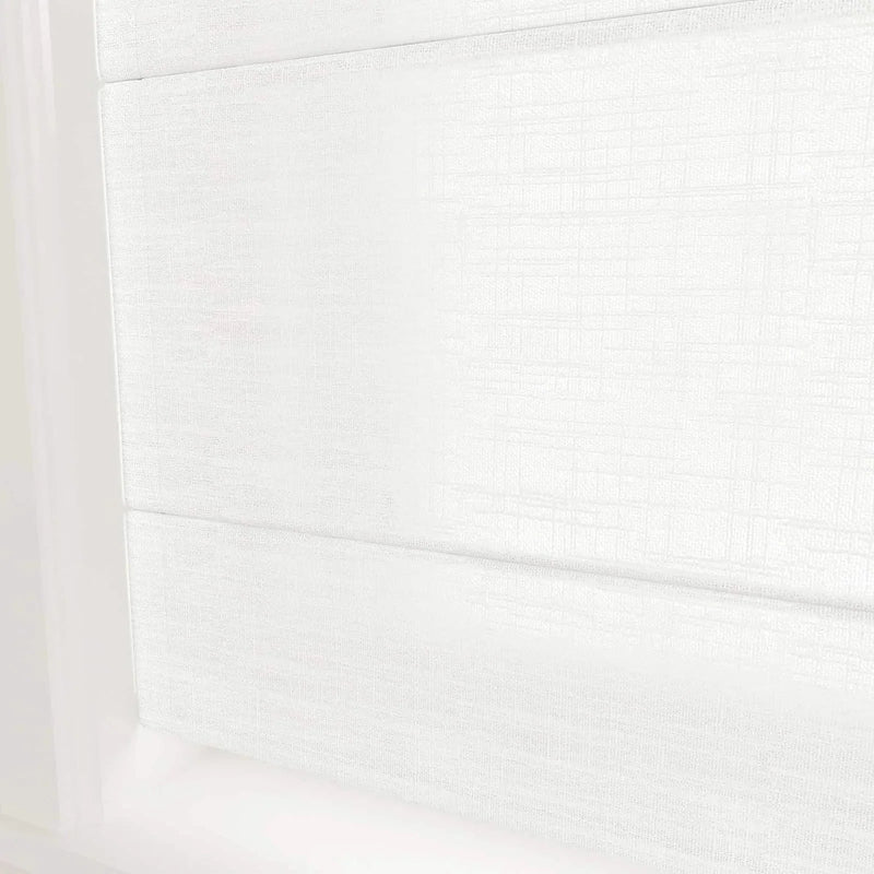 A pure white fabric Roman window blind with a subtle woven texture and gentle horizontal folds filtering light in a modern interior