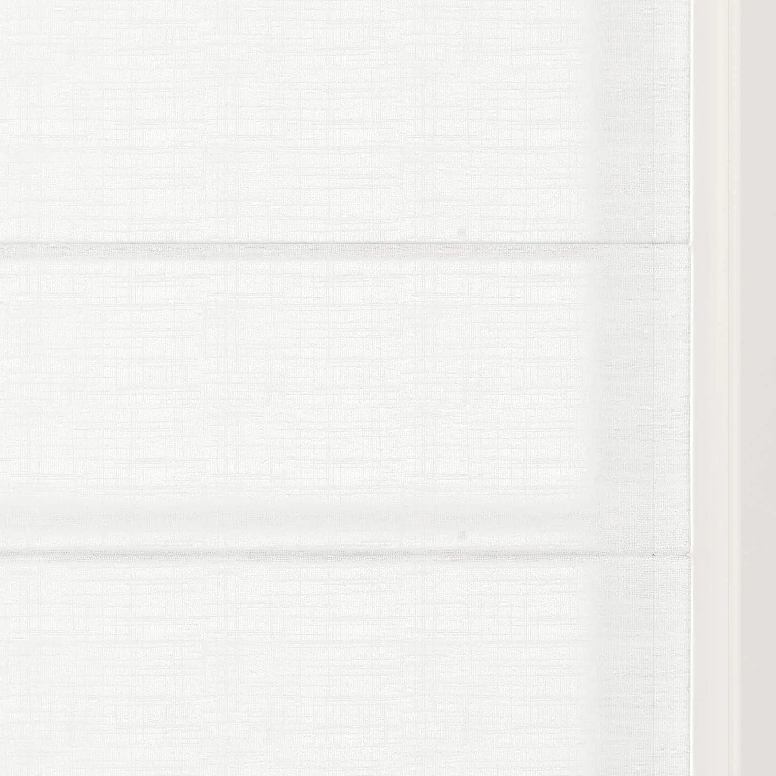 Photograph of a minimalist white Roman shade featuring prominent horizontal folds and a fine linen-like texture