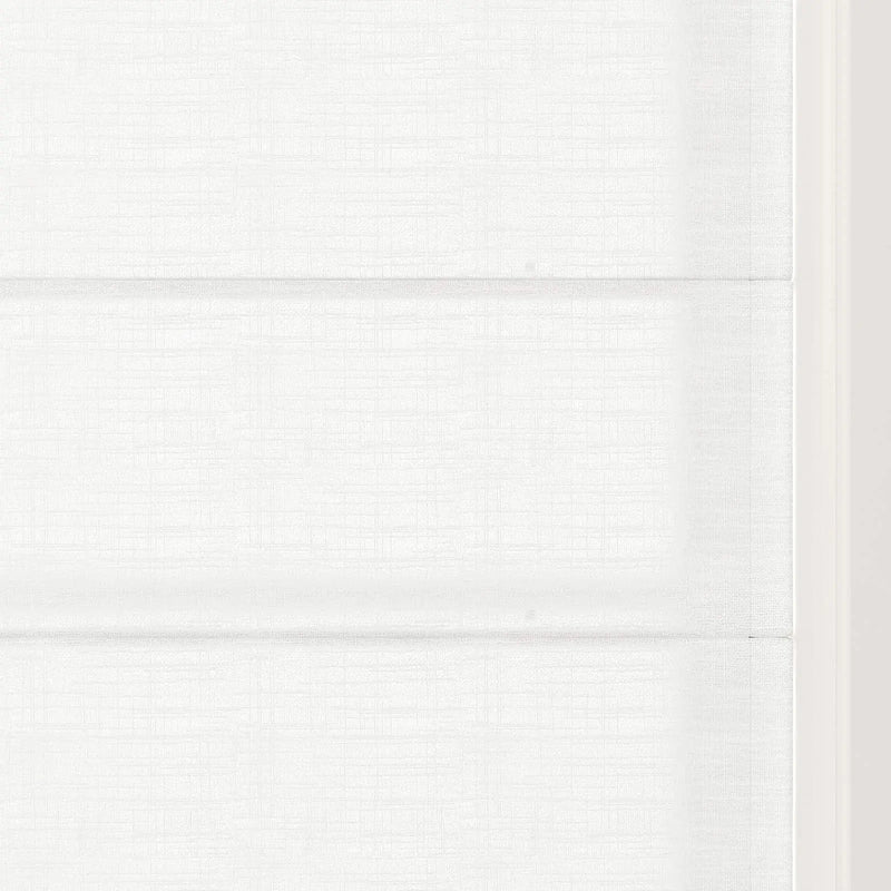 Photograph of a minimalist white Roman shade featuring prominent horizontal folds and a fine linen-like texture