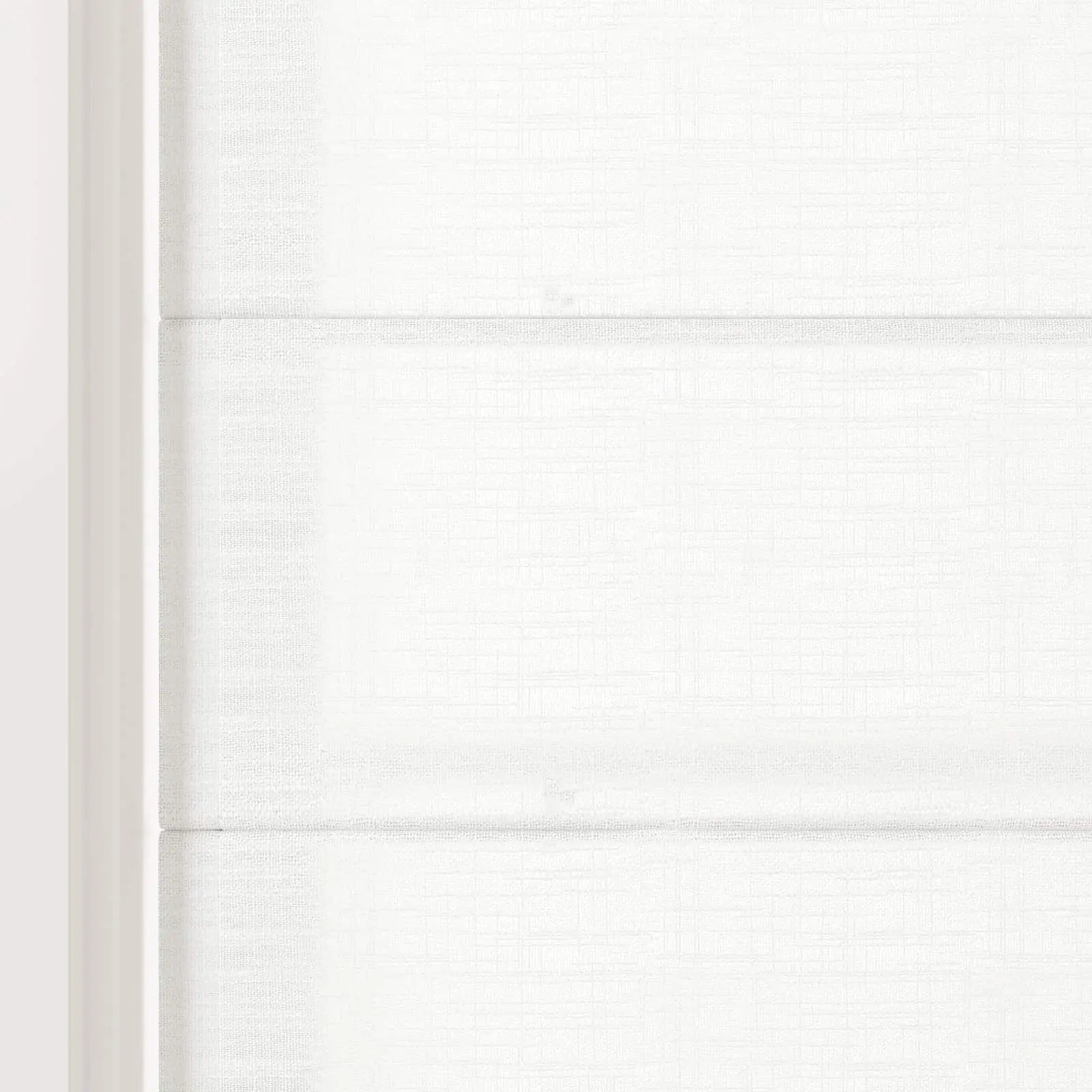 Digital photograph of a white Roman blind on an interior window featuring textured fabric with a subtle grid pattern soft horizontal folds and a crisp white frame on the left