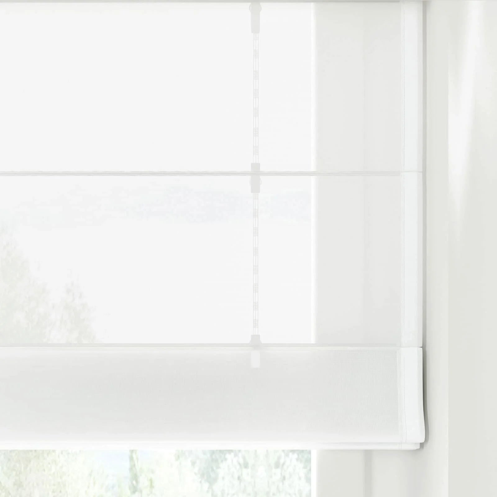 A translucent white Roman blind with clean horizontal folds and visible lift cords featuring small clips, gently filtering natural light from an outdoor green landscape