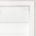A close-up of a double-layered white textured fabric window shade installed within a bright white wooden window frame providing a minimalist aesthetic