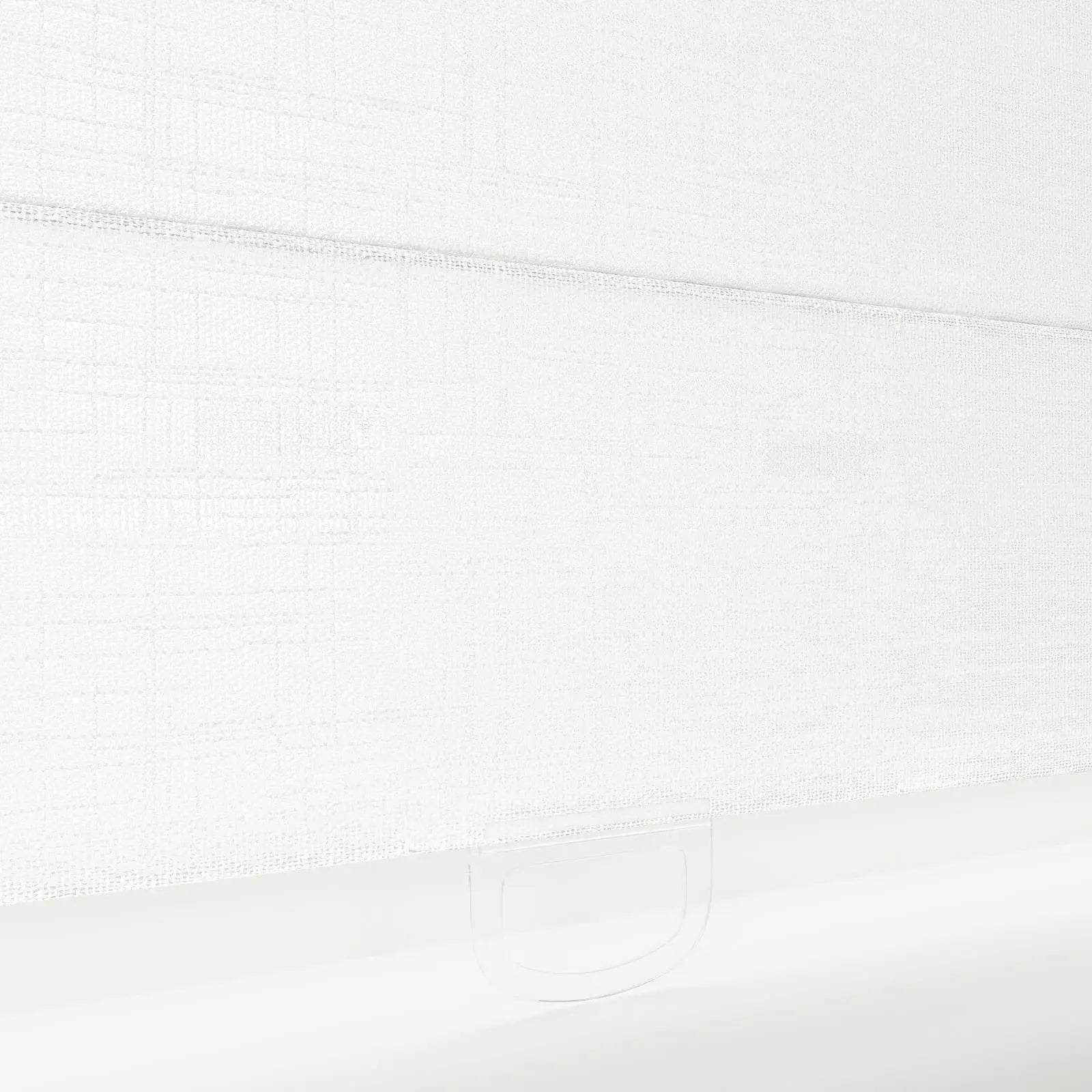 A crisp white textured fabric Roman blind displaying a subtle grid pattern and a clear plastic handle loop