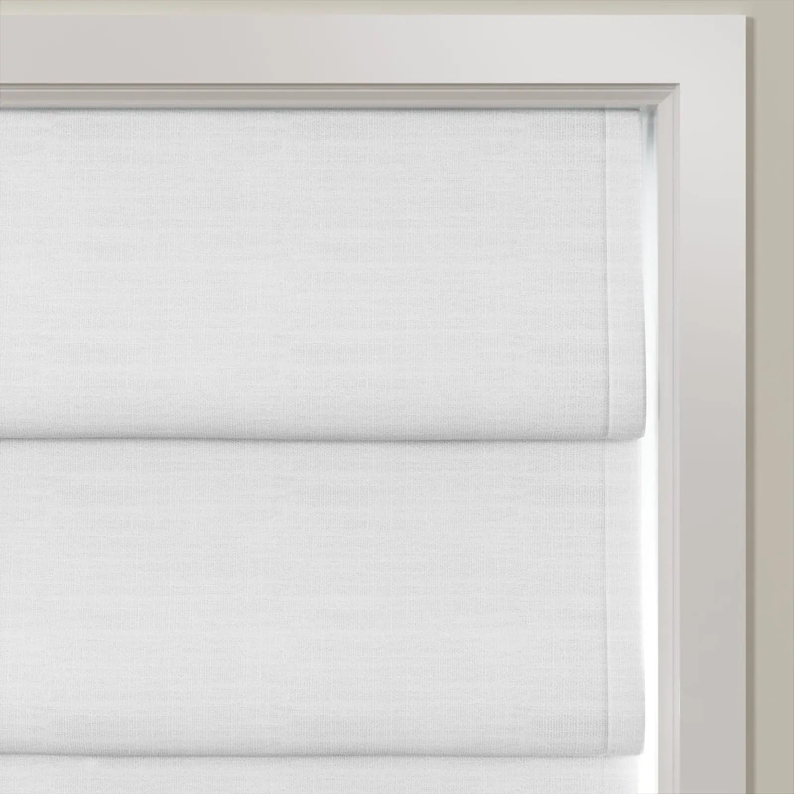 White textured Roman shades partially lowered on an interior window with a crisp white frame showcasing neat horizontal fabric folds