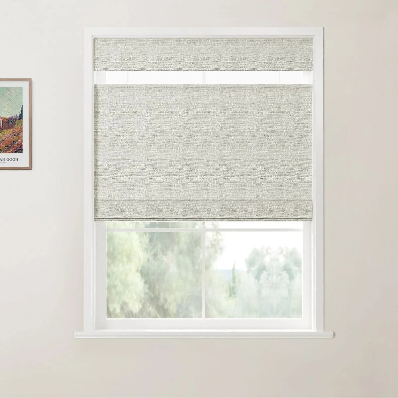 Photograph of a room interior featuring a white-framed window with a light grey textured Roman blind partially lowered over a view of blurred green trees, alongside a framed print of a colorful Van Gogh painting on the adjacent wall