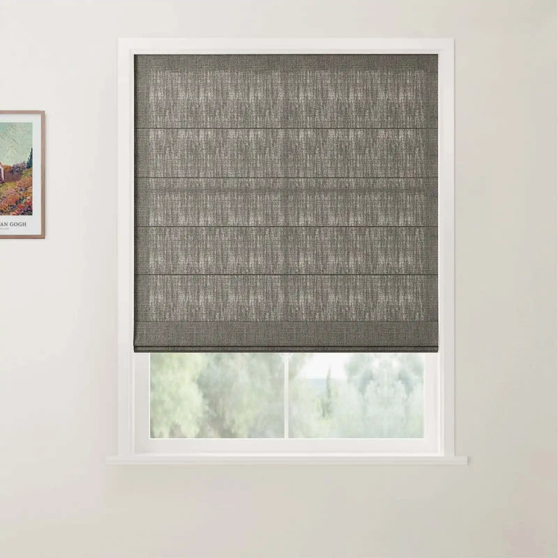 Photograph of a window featuring a dark grey textured Roman blind with horizontal pleats partially open to a blurred green outdoor view, with a framed Van Gogh print depicting a vibrant landscape visible on the left wall