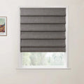 Textile dark gray textured Roman blind covering a window in a light-colored room, partially open to reveal a soft green outdoor landscape, with a framed print of Vincent van Gogh's Wheat Field with Cypresses visible on the adjacent white wall