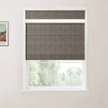 Photograph of an interior showing a framed Van Gogh landscape print on the wall, a dark grey textured Roman blind in a white window, and a lush green outdoor scene