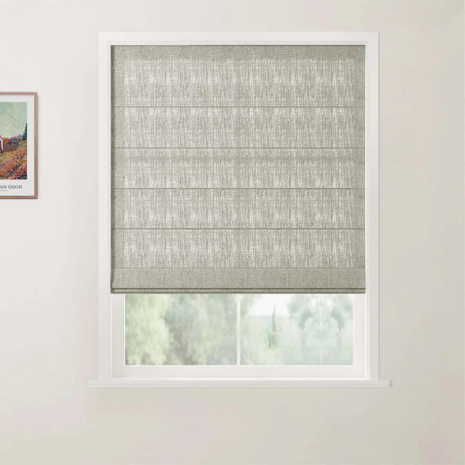 Photograph showing a window with a textured grey-green Roman blind and white frame, beside a framed Van Gogh colorful landscape print featuring a house and trees on a white wall