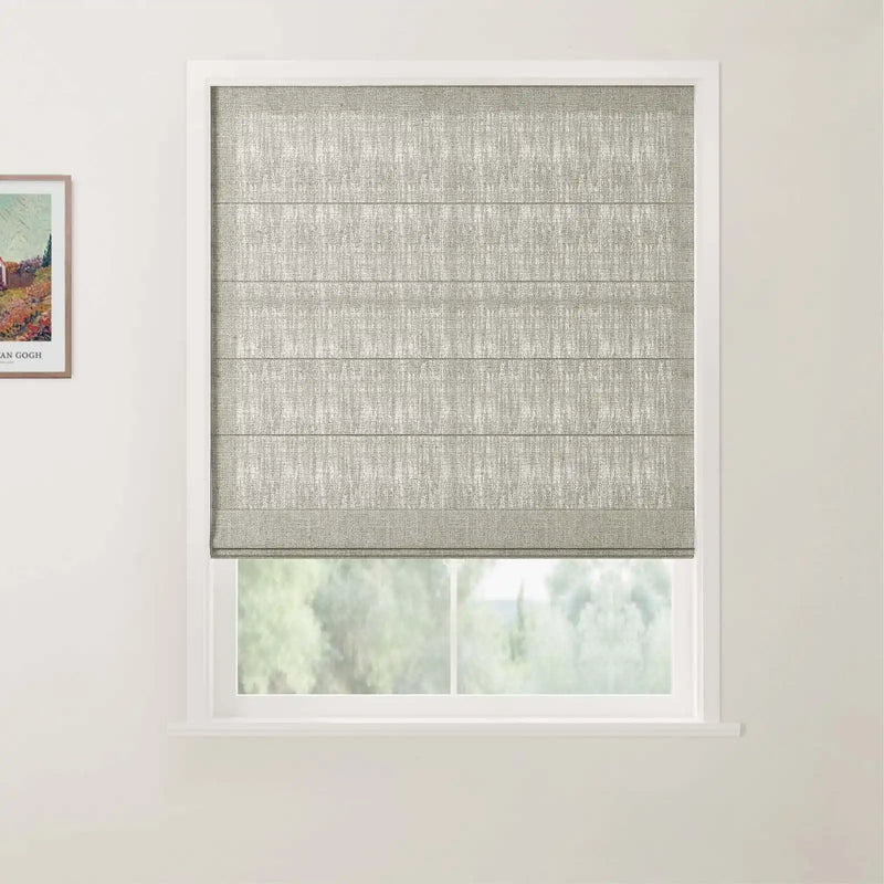Photograph showing a window with a textured grey-green Roman blind and white frame, beside a framed Van Gogh colorful landscape print featuring a house and trees on a white wall