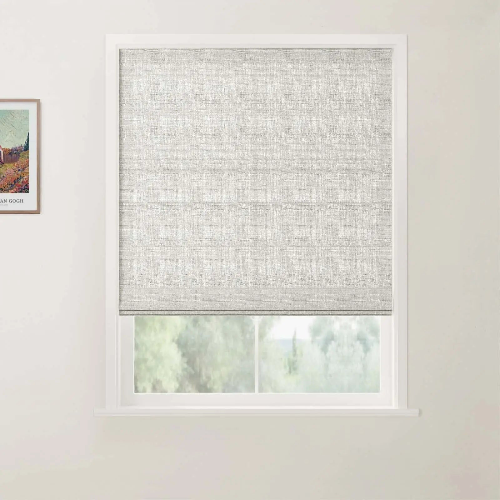 Photograph showcasing a white window with a textured light grey Roman blind, adjacent to a framed Van Gogh print depicting a vibrant landscape, overlooking a blurry green outdoor scene