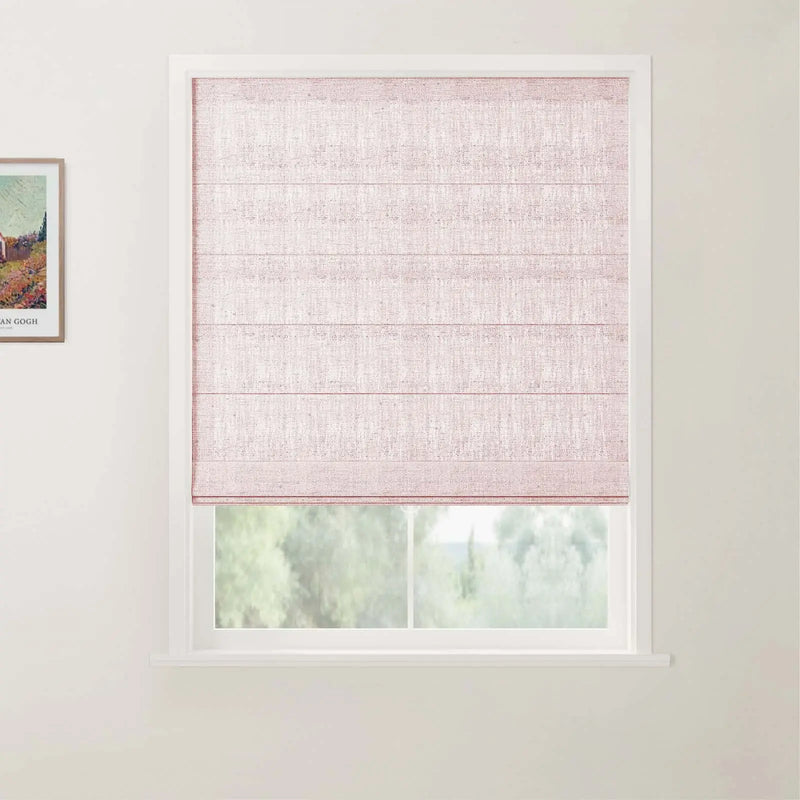 Photograph of an interior with a light pink linen Roman blind covering a white window frame, offering a blurred view of green trees outside, and a colorful framed Van Gogh landscape print visible on the adjacent wall