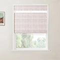 Photograph of a white-framed window showcasing a light pink textured Roman blind with a top-down bottom-up feature, revealing lush green trees outside and a framed Van Gogh art print on the left wall