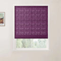 Photograph of a vibrant purple textured Roman blind partially covering a white-framed window looking out to soft green foliage, with a framed Van Gogh landscape print visible on the adjacent light wall