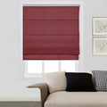 A maroon Roman blind in a modern living room featuring a beige textured sofa a black and white houndstooth throw pillow and two framed abstract artworks