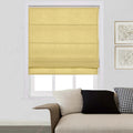 A modern living room interior featuring a window with a bright yellow Roman shade, part of a beige textured sofa accessorized with a black solid pillow and a black and white houndstooth pillow, and two framed abstract prints on the white wall