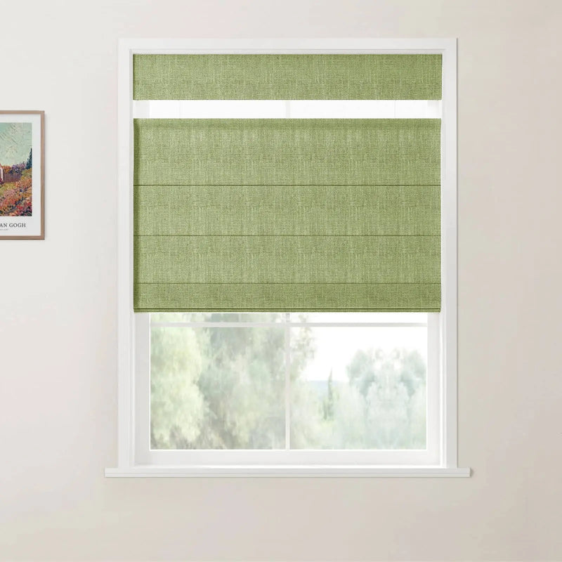A light green textured Roman blind partially covers a white-framed window overlooking blurred trees, with a framed Van Gogh print visible on the adjacent white wall