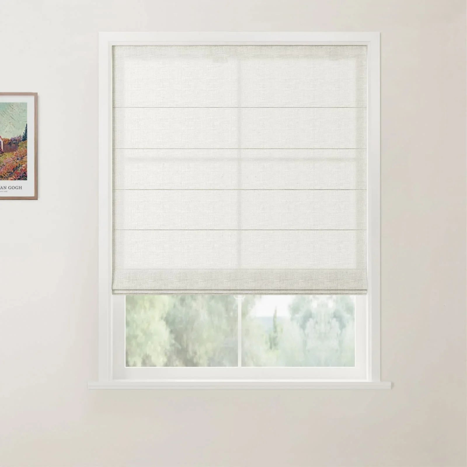 Photograph of a white framed window featuring a textured off-white Roman blind partly drawn over a view of lush green trees, with a framed Van Gogh Flowering Garden painting print on the left wall