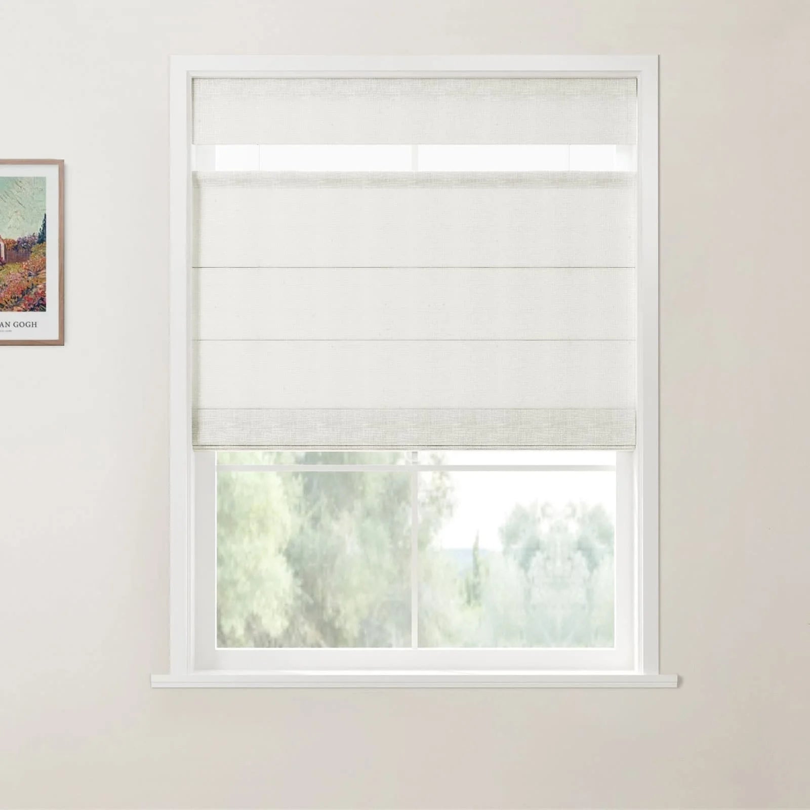 Print of a colorful landscape by Van Gogh on a light wall next to a window featuring white linen-textured Roman blinds partially open above a blurred green outdoor view