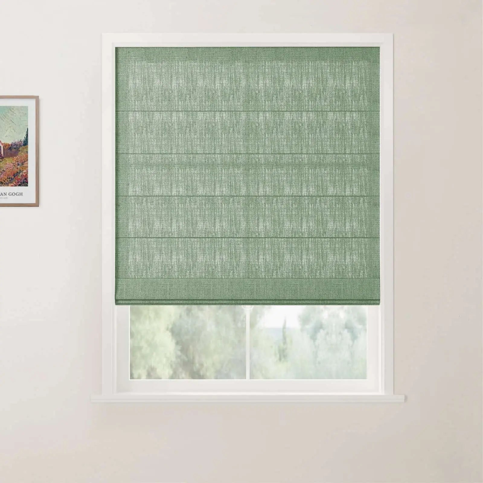 Photograph of a window in a room featuring a textured sage green Roman blind, white frame and sill, blurred green trees outside, and a framed Van Gogh print on the left wall