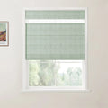 Photograph, an interior room features a window with sage green textured Roman blinds and a white frame, overlooking a blurred natural landscape, with a framed Van Gogh art print on the adjacent light wall
