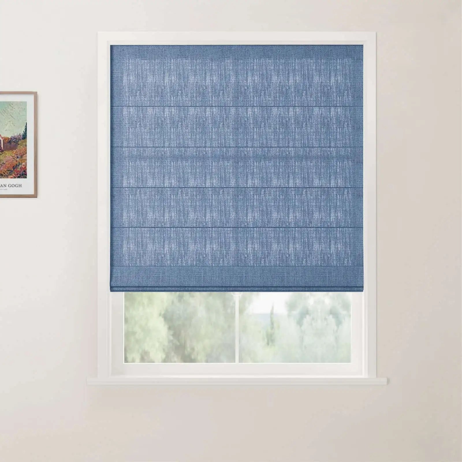 Photograph of a white-framed window featuring a blue textured Roman blind partially lowered over a view of green foliage outside, with a framed Van Gogh print on the adjacent wall