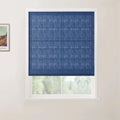 Interior view of a window with a dark blue textured Roman blind, a white frame, and a partial outdoor view of green foliage, complemented by a framed Van Gogh print depicting a colorful house and fields on the adjacent wall