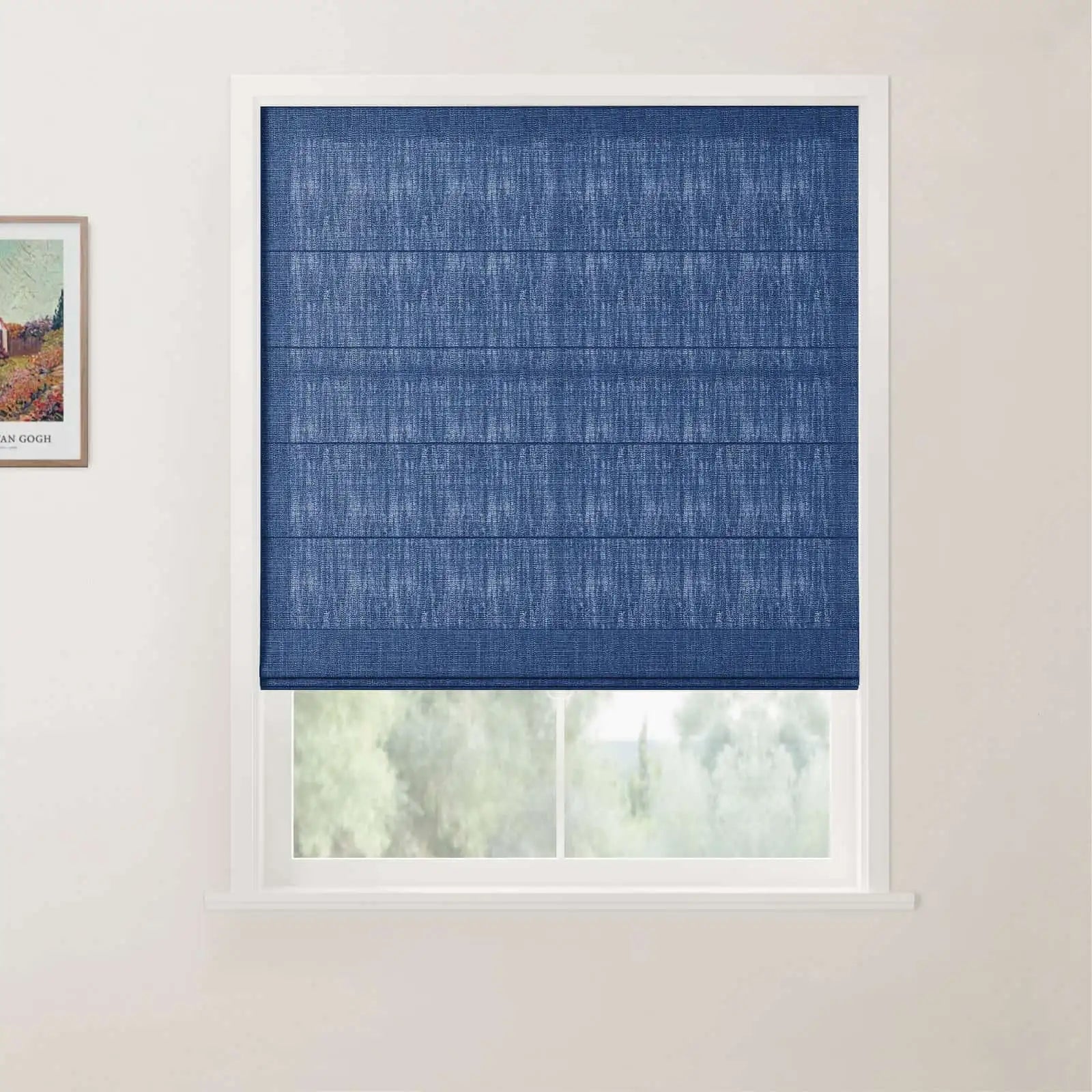 Interior view of a window with a dark blue textured Roman blind, a white frame, and a partial outdoor view of green foliage, complemented by a framed Van Gogh print depicting a colorful house and fields on the adjacent wall