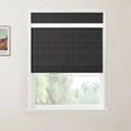 Photograph of a window featuring charcoal grey top-down bottom-up Roman blinds in a white frame, with a framed Van Gogh print on the adjacent wall and blurred green foliage visible outside