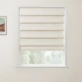 A framed Van Gogh landscape print hangs beside a white window featuring a semi-drawn beige textured Roman blind revealing blurred green trees