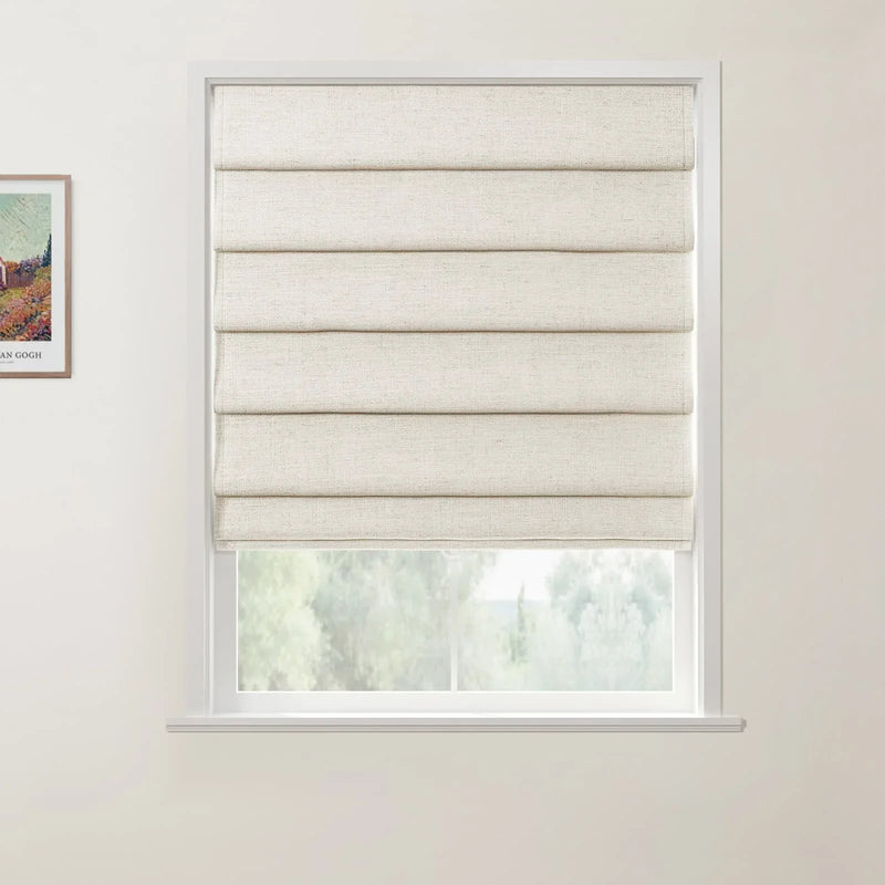 A framed Van Gogh landscape print hangs beside a white window featuring a semi-drawn beige textured Roman blind revealing blurred green trees