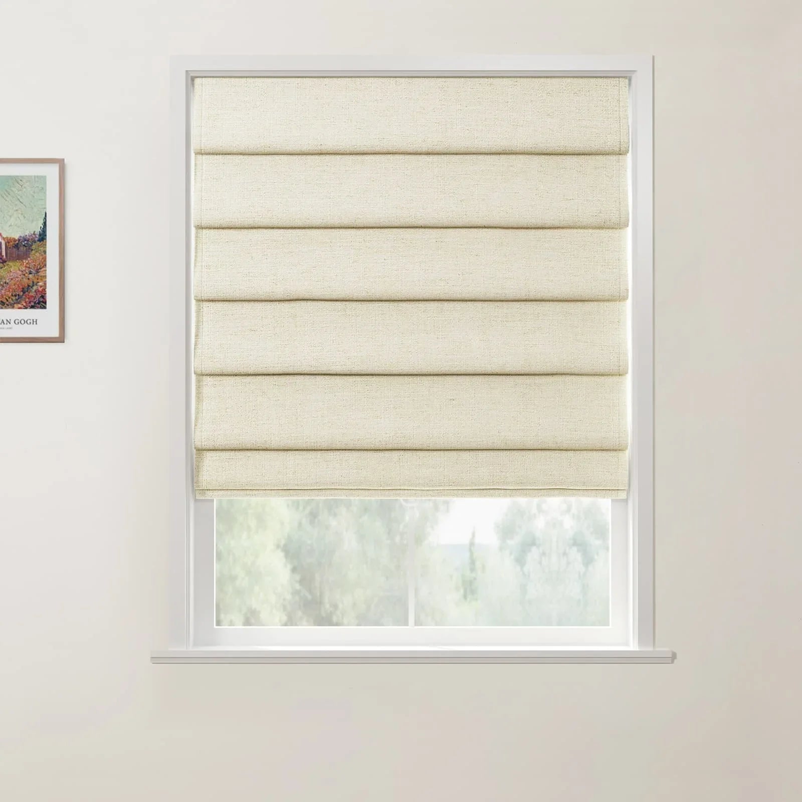 Photograph of a bright interior room featuring a cream textured Roman blind with horizontal folds partially drawn over a white window frame, offering a blurred view of green trees outside, with a framed Vincent Van Gogh Wheat Field with Cypresses poster visible on the left wall