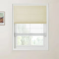 Photograph a modern interior with a white-framed window featuring a beige textured Roman blind over a sheer white blind and a framed Van Gogh Arles landscape print on the wall