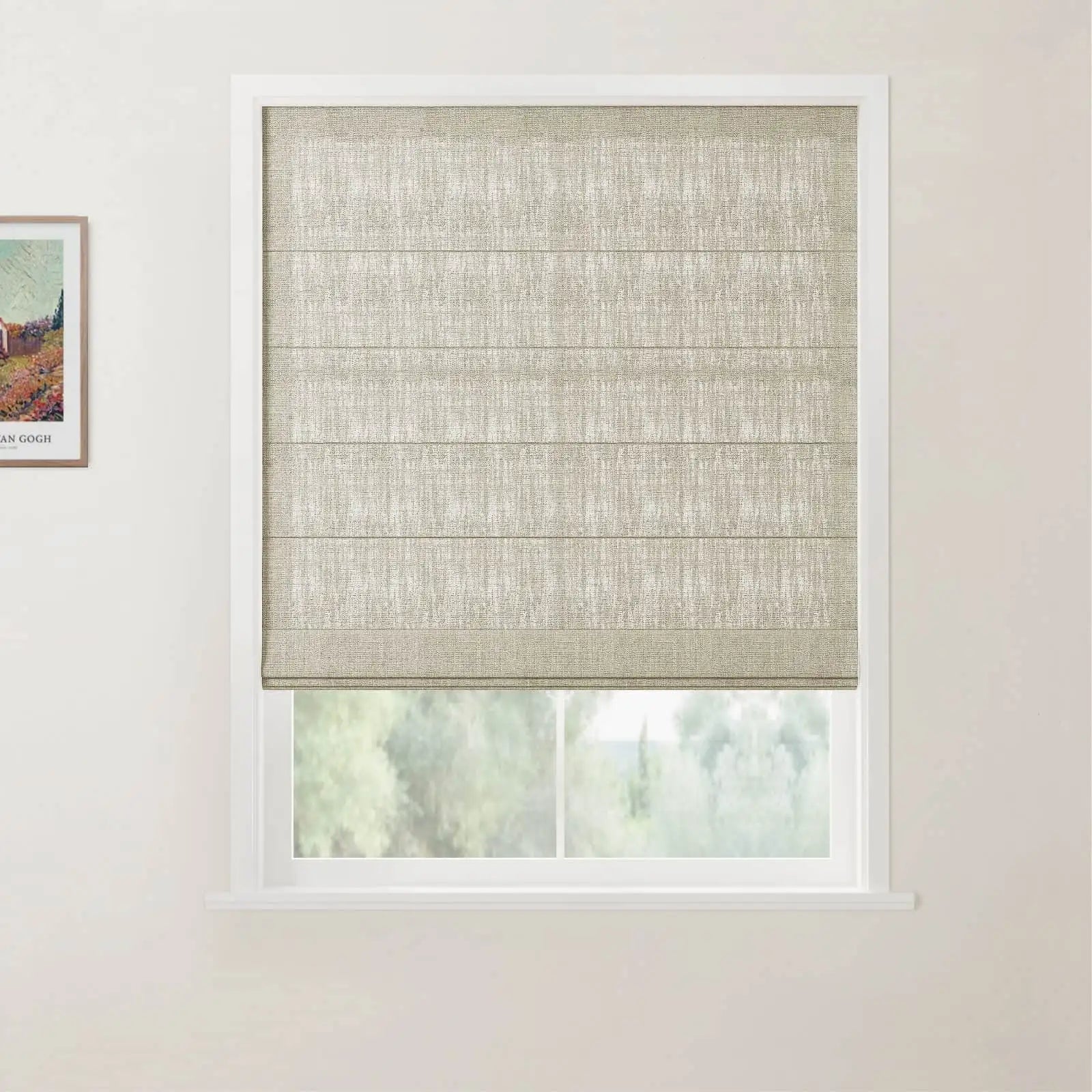 Photograph of a window featuring a textured beige Roman blind partially raised, revealing green outdoor foliage, set against a white wall with a framed Van Gogh print