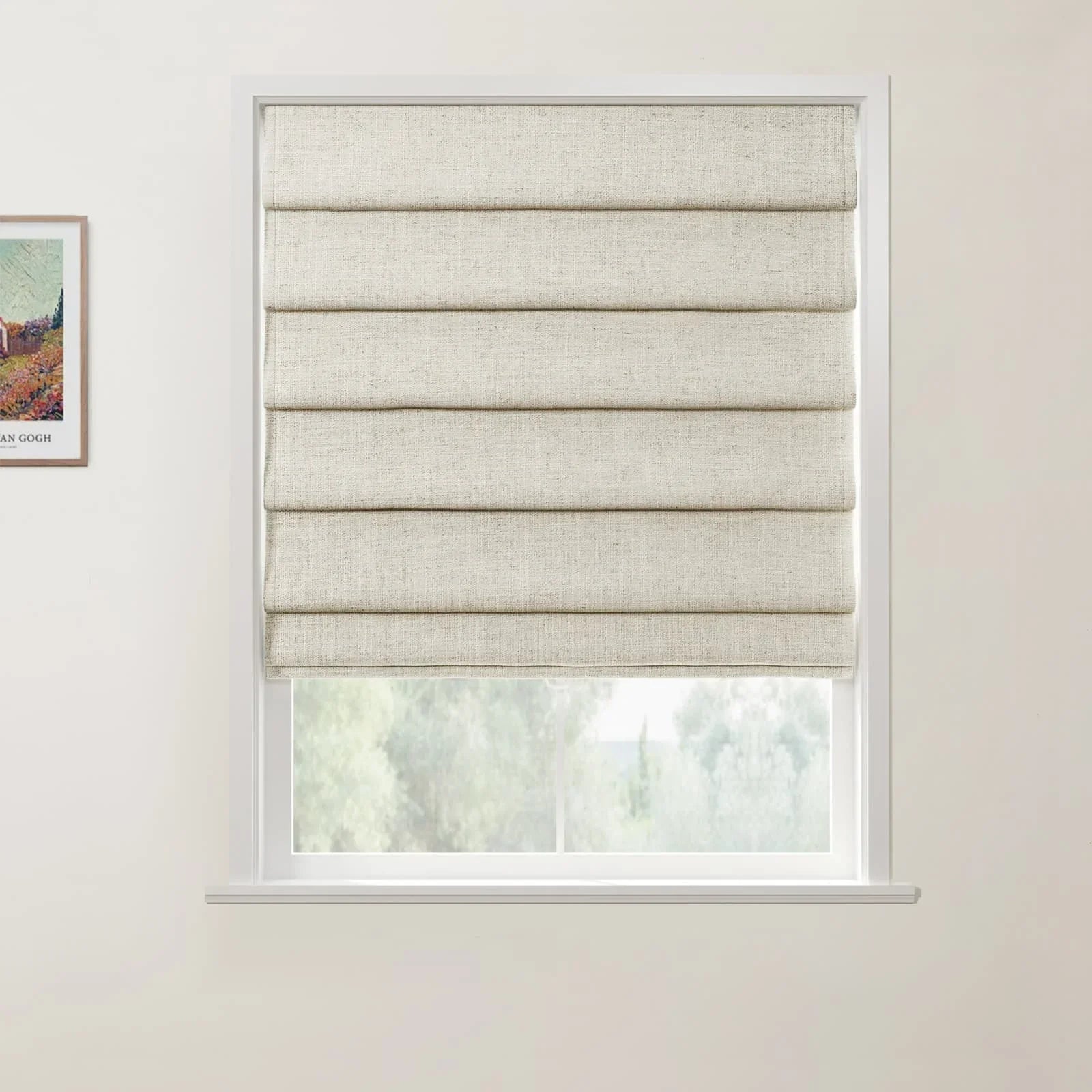 A photograph showing a window in an interior room with a textured beige Roman blind half-closed revealing a view of green trees, and a framed Van Gogh landscape print on the adjacent white wall