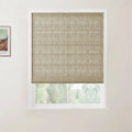 White-framed window showcasing a textured light brown roman blind partially revealing a blurred green outdoor view next to a framed Van Gogh landscape print