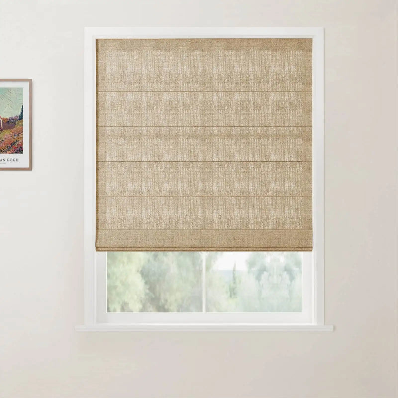 Photograph of a window with a natural textured beige Roman shade set in a white frame, a framed Van Gogh print on the left wall, and blurred green foliage visible outside