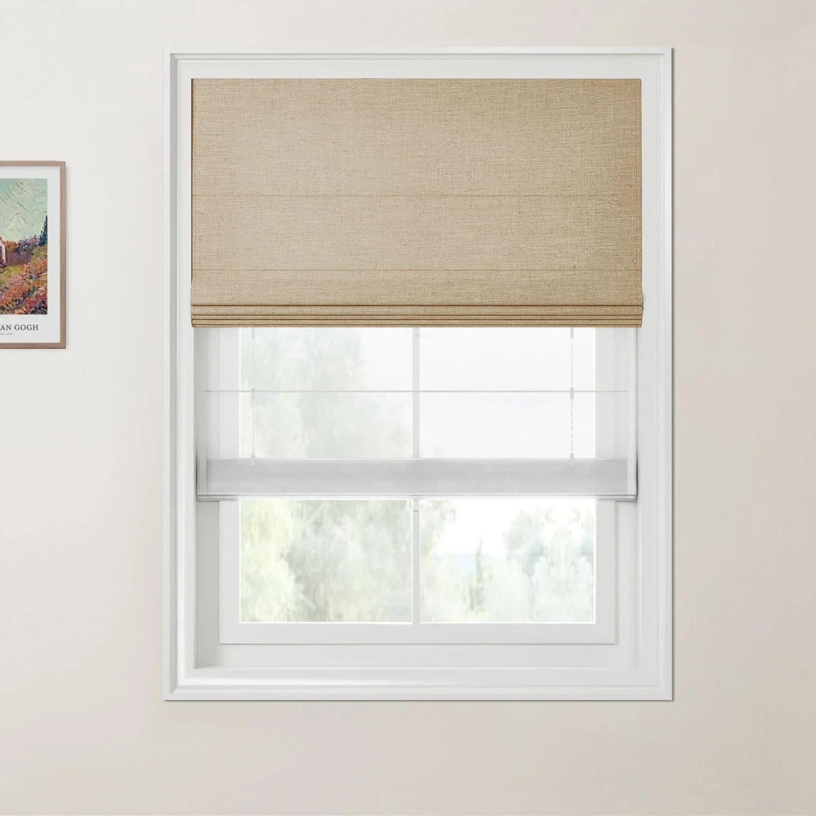 Photograph of an interior featuring a window with a tan woven Roman blind and a sheer white bottom-up blind alongside a framed print of Van Gogh's A Wheatfield, with Cypresses on a cream-colored wall