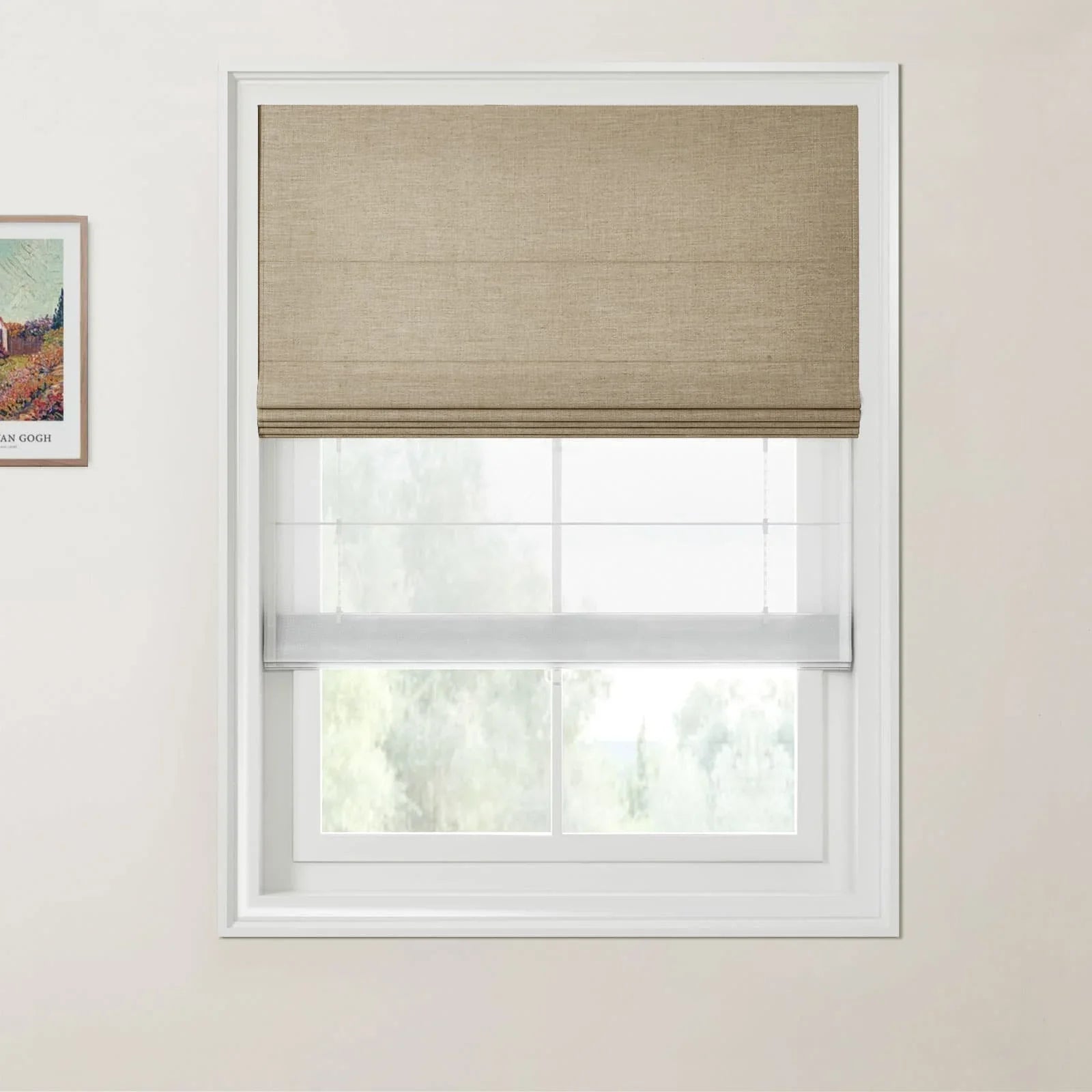 Van Gogh print of a vibrant landscape next to a window with a beige textured Roman shade and a white sheer bottom shade looking out to green trees