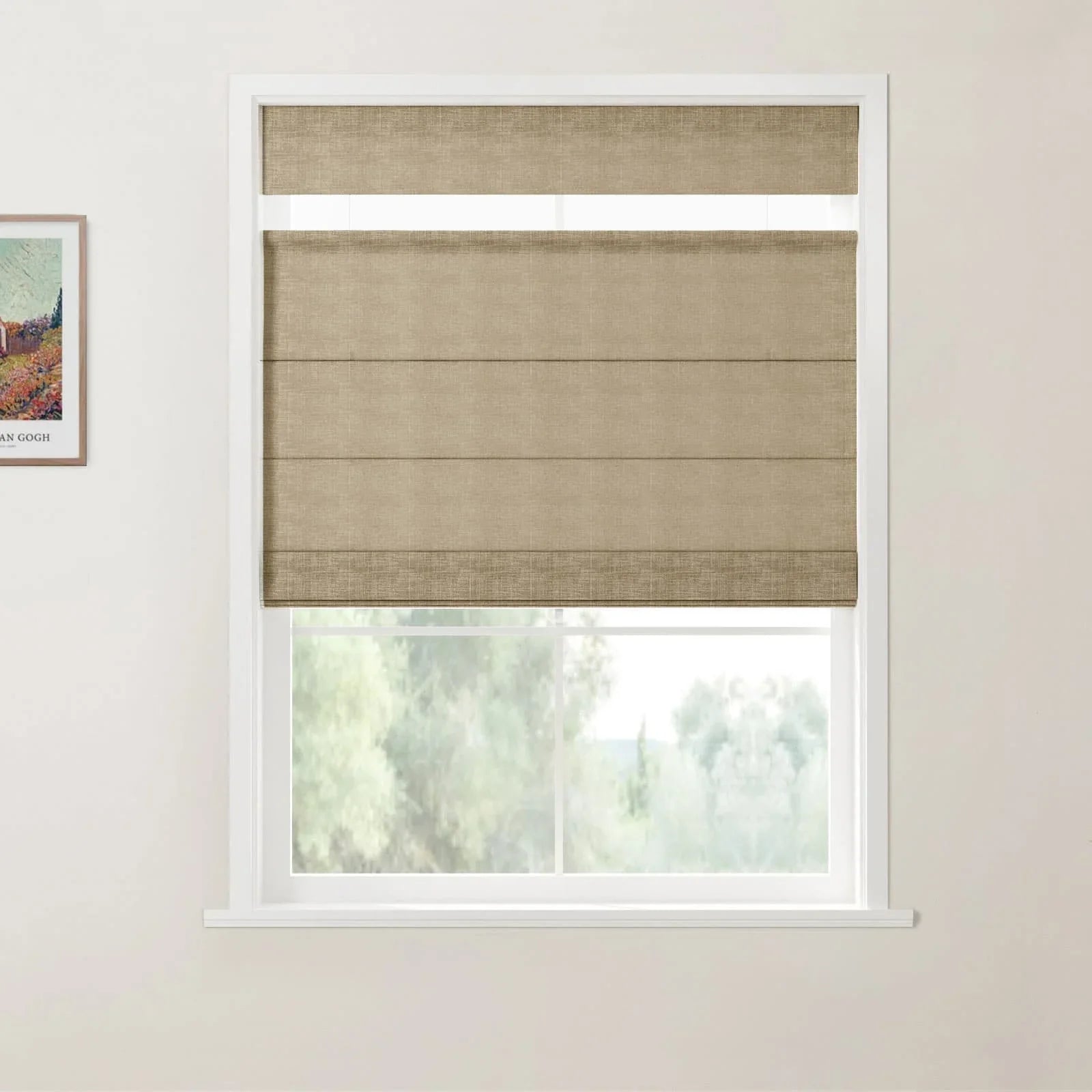 Print by Van Gogh showing a landscape with a house and field is partially displayed on a light wall, adjacent to a white-framed window fitted with a textured beige top-down bottom-up Roman blind that reveals blurred green trees