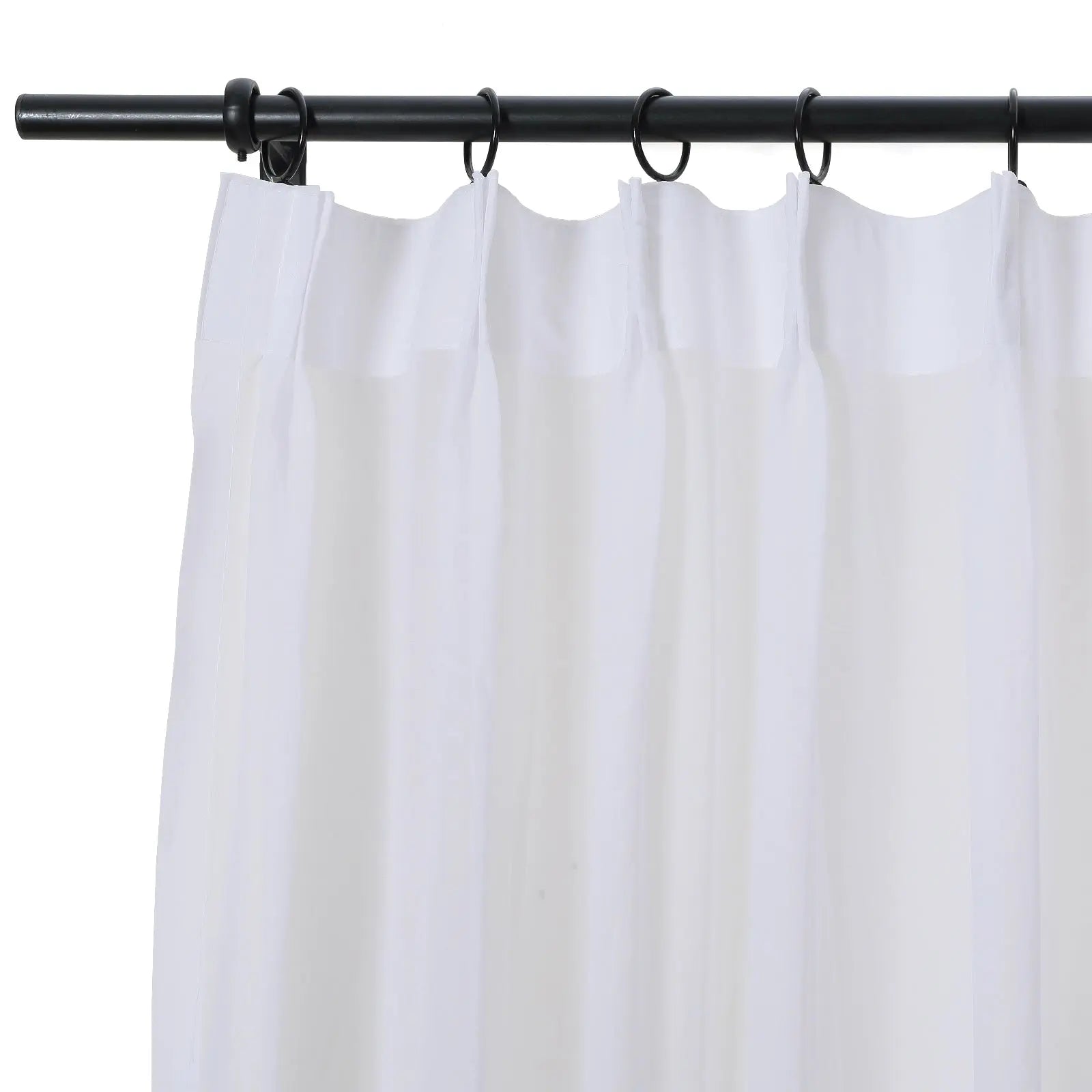A white semi-sheer curtain with a neatly pleated top hangs from a black metal rod using black circular rings
