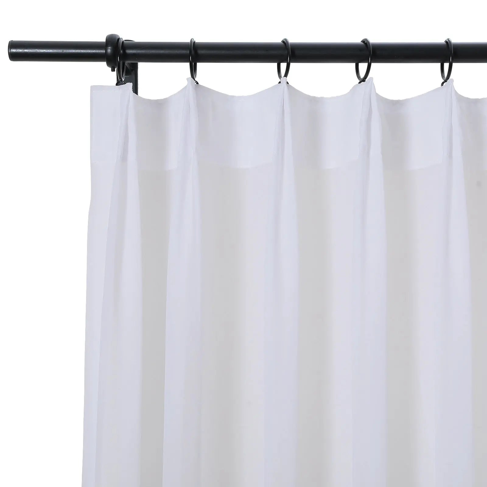 Photograph of a sheer white curtain with a gathered top hanging from a black metal rod using black round rings in an interior setting