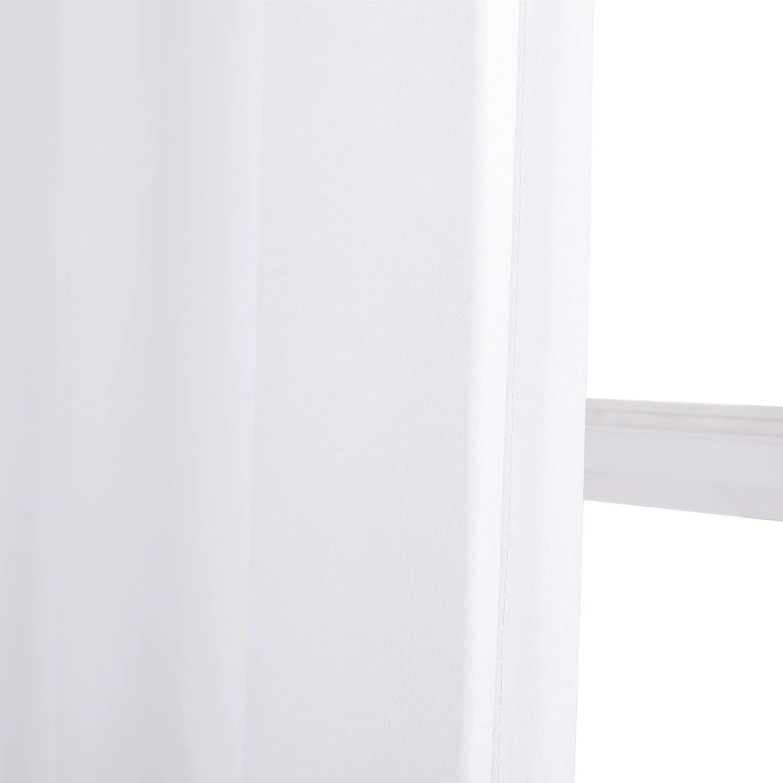 Photograph of a sheer white curtain with a subtle woven texture and soft vertical folds, partially revealing a clean white window frame