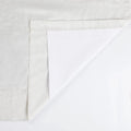 Textured light grey fabric with a white backing revealed by a corner fold and visible hem