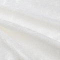 Photograph of textured white fabric displaying soft diagonal folds and subtle cream-colored shadows