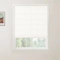 Framed print of a Van Gogh landscape painting hangs on a light wall beside a window with a white woven Roman blind revealing a blurry green outdoor view